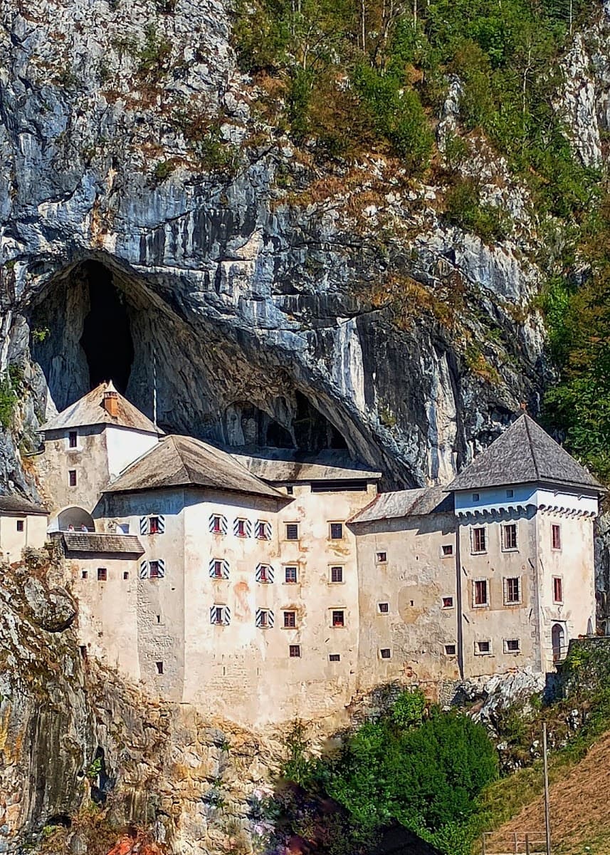 Historic castle built into a rocky cliffside cave opening